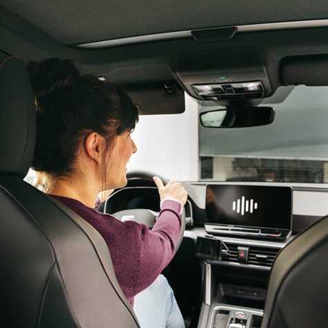 lady driving using voice command to open somfy garage door