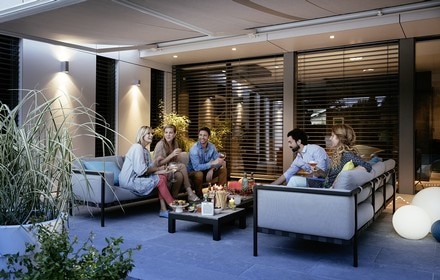 Friends enjoying nibbles under a motorised awning